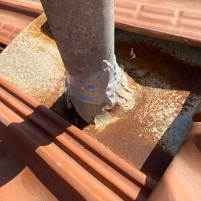 צינור מתכת עם איטום על גג רעפים חלוד