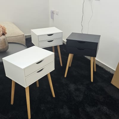 שולחנות צד מעץ עם מגירות על שטיח שחור