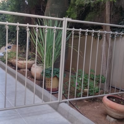 שער מתכת פתוח עם עמודים אנכיים