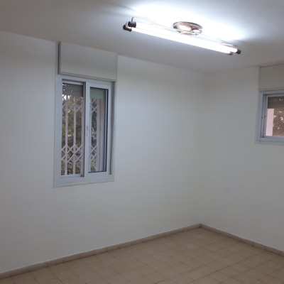 חדר עם קירות צבועים בלבן ותאורה עליונה