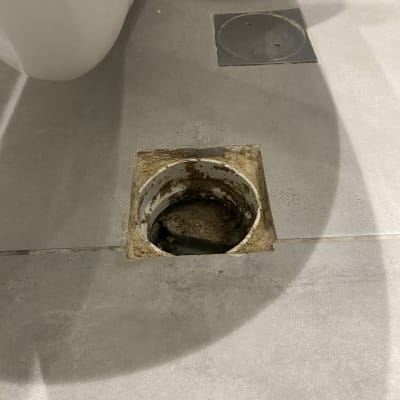 פתח ניקוז ברצפה עם לכלוך מסביב