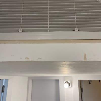 תריס מיזוג אוויר על קיר לבן עם כתמי צבע