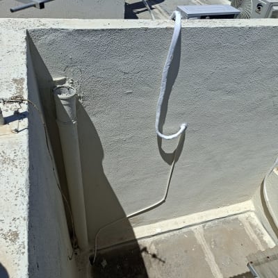 יחידת מיזוג אוויר מותקנת על גג עם צינורות חשמל.