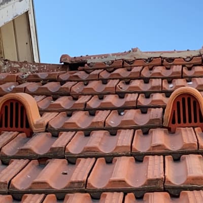 רעפים חומים עם פתחי אוורור על גג