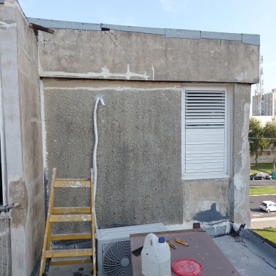 סולם צהוב ליד קיר עם חומרי איטום