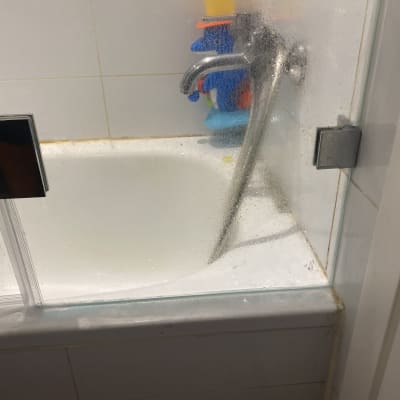 דלת זכוכית למקלחת עם ברז וכמה צעצועים צבעוניים