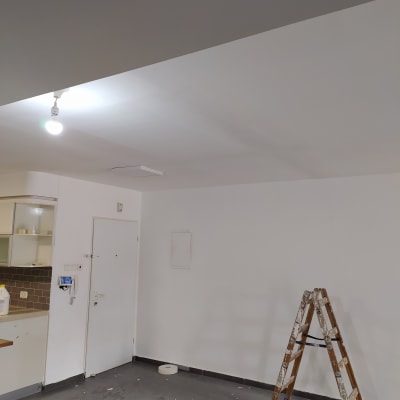 סולם עץ עם כתמי צבע על רצפה מלוכלכת