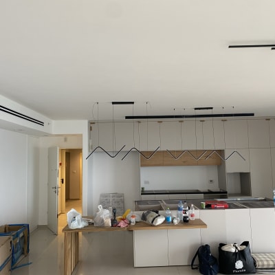 מטבח חדש עם ארונות לבנים ותאורה תלויה
