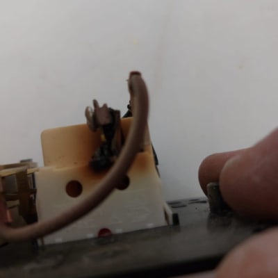 חוט חשמל מחובר לשקע עם סימני שריפה