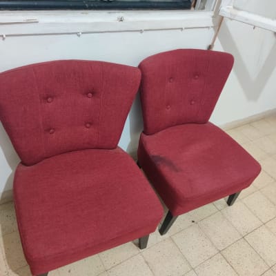שני כיסאות אדומים עם כתם על אחד מהם
