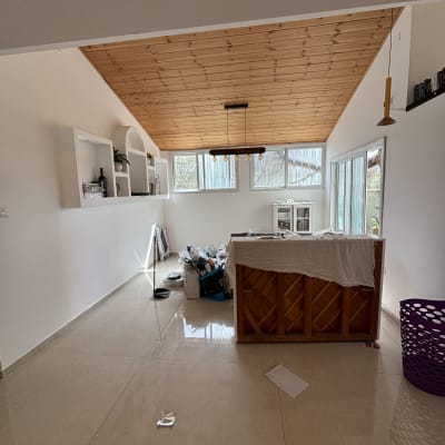 חדר עם תקרה מעץ, קירות צבועים ולוח עבודה