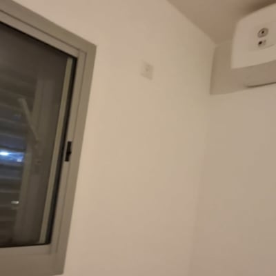 חלון ומזגן מותקן על קיר לבן