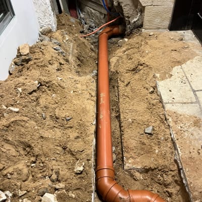 צינור כתום מותקן בתעלה באדמה