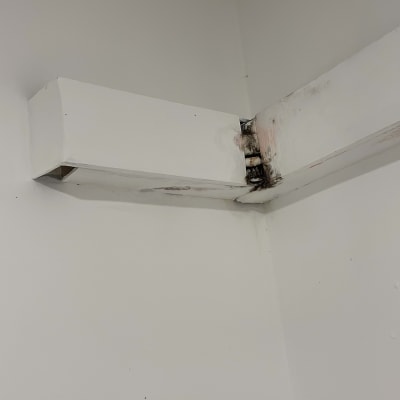 צינור אוורור מותקן על קיר לבן