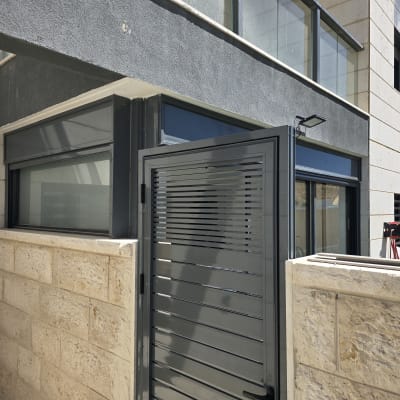 שער אלומיניום אפור ליד חלון זכוכית