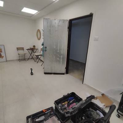 דלת מתכת פתוחה עם סימני ציפוי וכלי עבודה