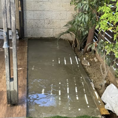 משטח בטון חדש ליד דשא ועצים