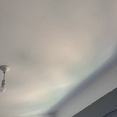 מנורה תלויה מהתקרה ליד חלון עם תריסים