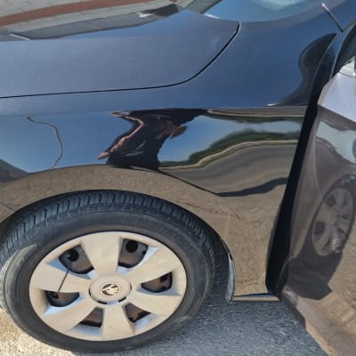 מכונית שחורה עם פגוש קדמי וצמיגים