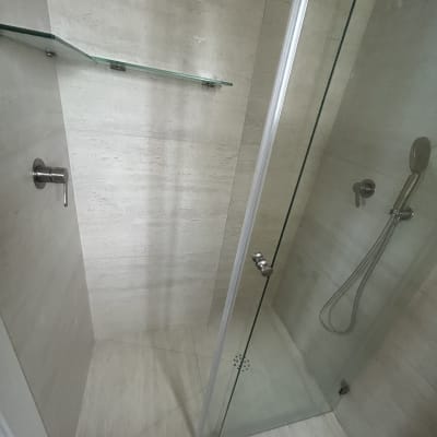 מקלחת עם דלת זכוכית ומדף זכוכית