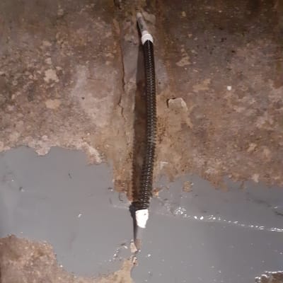 כבל חשמל שחור עם חיבור לבן על רצפה אפורה