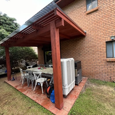 פרגולה מעץ עם שולחן וכיסאות בגינה