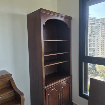 ארון עץ כהה הממוקם בחדר ליד חלון בדירת מגורים