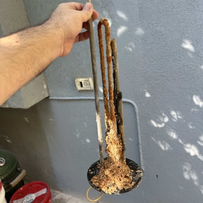 גוף חימום חלוד ומקולקל מוחזק ביד