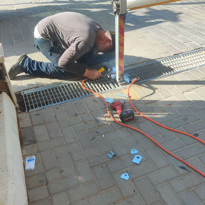 אדם מרתך מסגרת מתכת על מדרכה