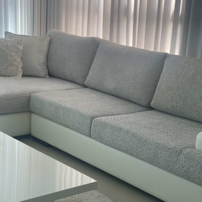 ספה אפורה עם כריות על ריפוד לבן