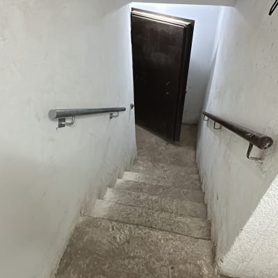 מדרגות עם מעקה מתכת ודלת פתוחה