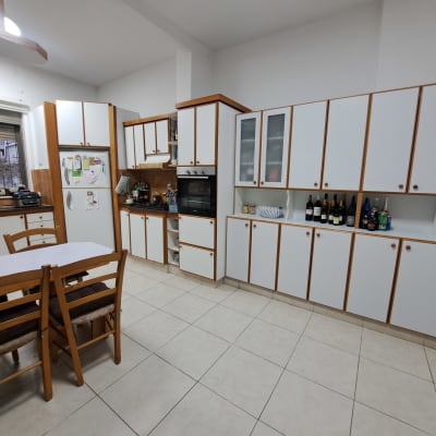 מטבח מאורגן עם ארונות לבנים ושולחן אוכל קטן