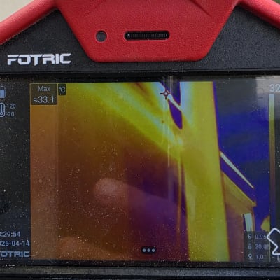 תמונה של מצלמה תרמית עם תצוגת חום על קיר חיצוני