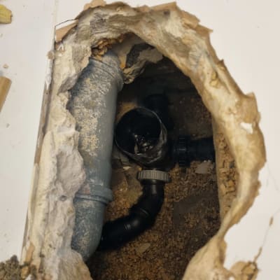 צינור ביוב חשוף בתוך קיר שבור
