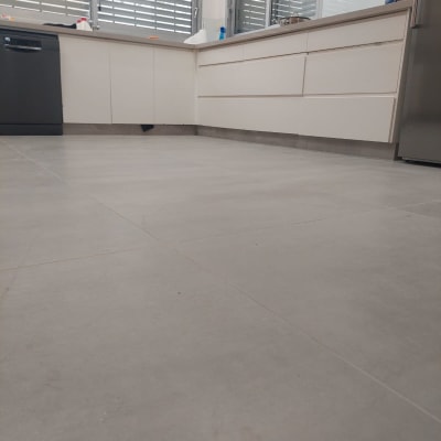 מטבח חדש עם ארונות לבנים ורצפת אריחים אפורה