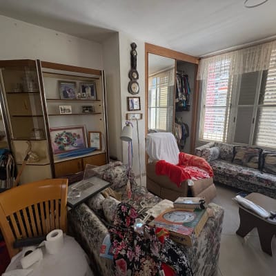 חדר מגורים עם רהיטים ופריטים שונים, ללא אנשים נראים