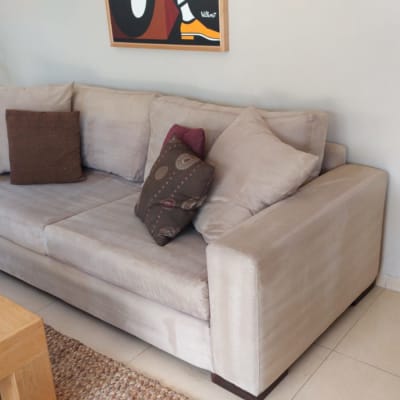 ספה בהירה עם כריות בסלון מואר