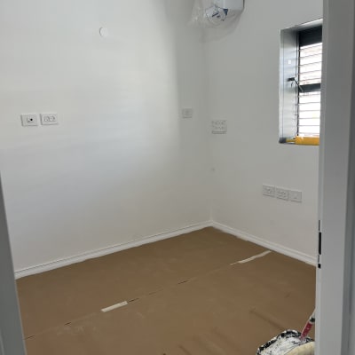 חדר עם קירות צבועים וגלגלת צבע על הרצפה