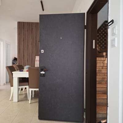 דלת כהה פתוחה עם ידית מתכתית ומנעול