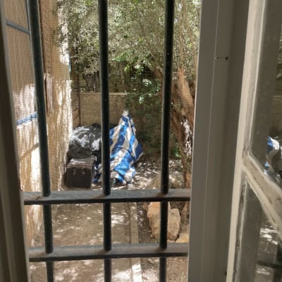 סורגי אלומיניום בחלון עם נוף חיצוני