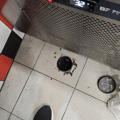 רצפה עם פתח ניקוז וכלי עבודה בתחום האינסטלציה