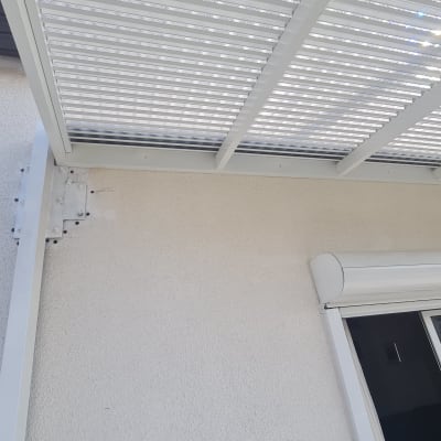 גג פרגולה מתכתית מחוברת לקיר עם ברגים