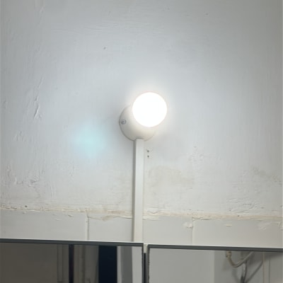 מנורה מותקנת על קיר עם חוטי חשמל גלויים