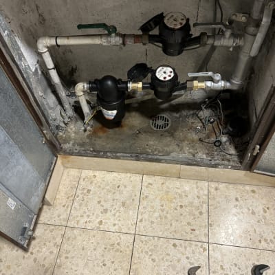 כלי עבודה של אינסטלטור ליד צנרת מים