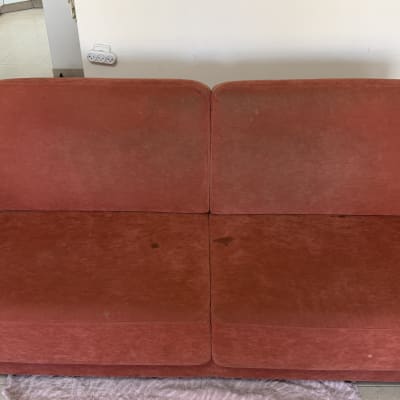 ספה אדומה עם כתמים על הרצפה