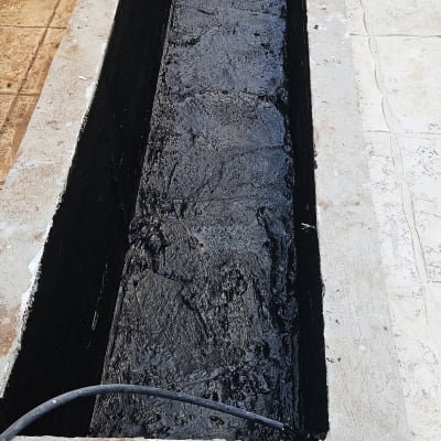 בריכה אטומה עם חומר שחור על רצפת בטון