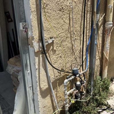 צינורות מים ומדי מים מחוברים לקיר חיצוני