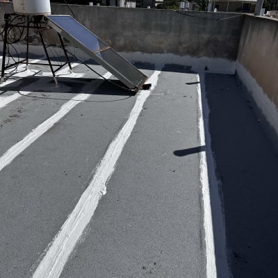 פסי איטום לבנים על גג אפור עם דוד שמש