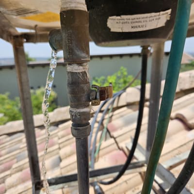 צינור דולף מחובר לדוד שמש על גג רעפים