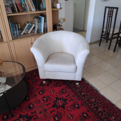 כורסה לבנה על שטיח אדום עם דוגמאות